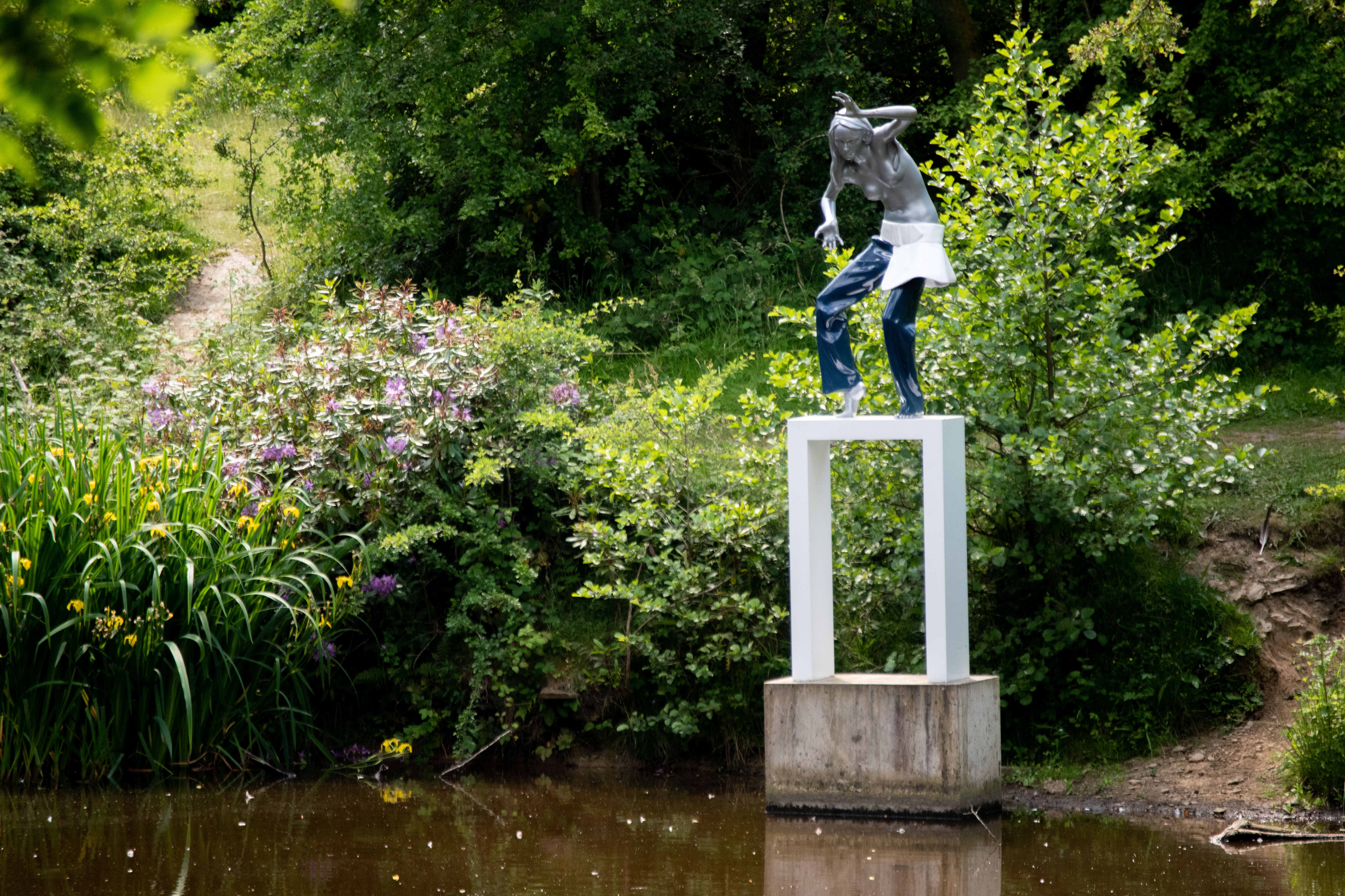 sculpture of woman on body of water